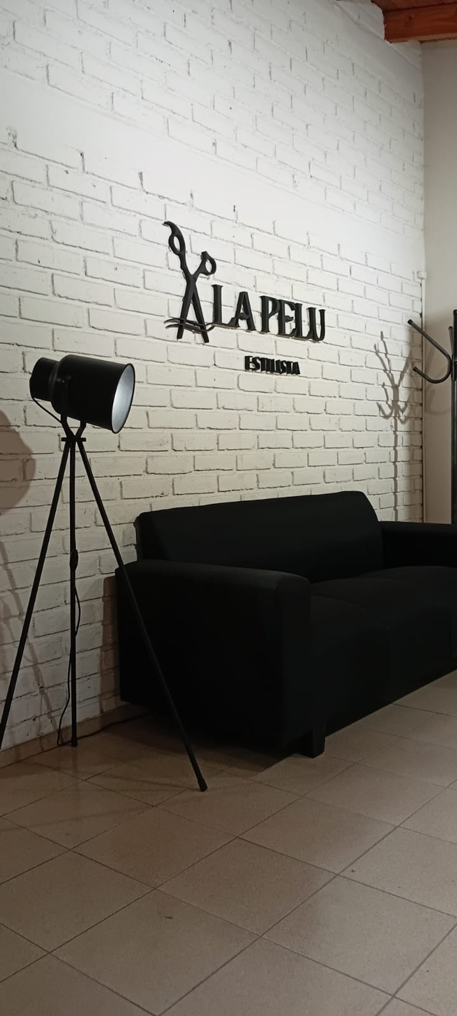 Local comercial con pared de ladrillo blanco y sillón negro — proyecto ALA PELU, por Yamil Cerna, en M5527 Corralitos